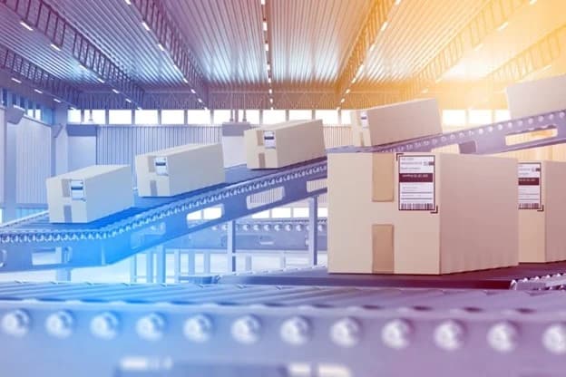 Cardboard packages moving along conveyor belt in Amazon fulfillment warehouse facility