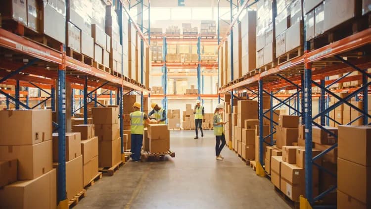 Warehouse workers in high-visibility vests managing inventory in modern fulfillment center