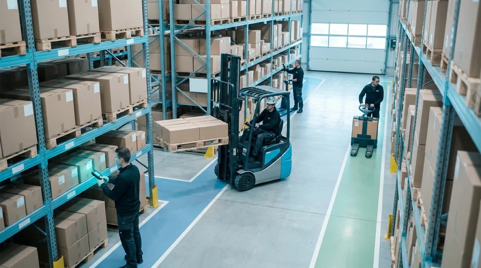 Warehouse workers operating forklifts and pallet jacks managing Amazon fulfillment inventory on shelves