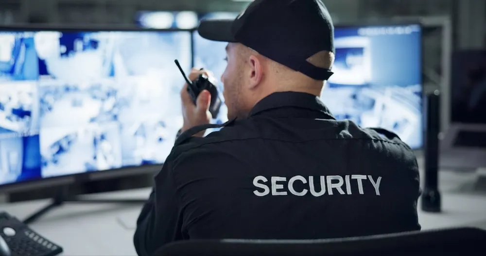 warehouse security guard watching cctv camera monitors