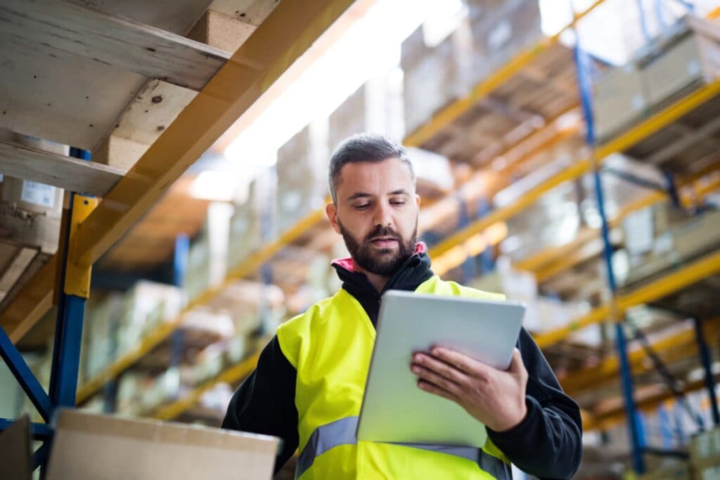 warehouse worker checking stock of an item on his tablet