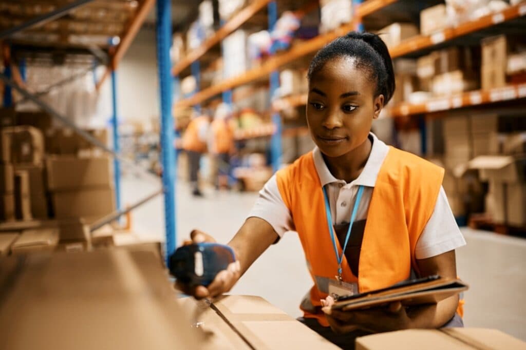 woman in warehouse scanning a barcode on a box