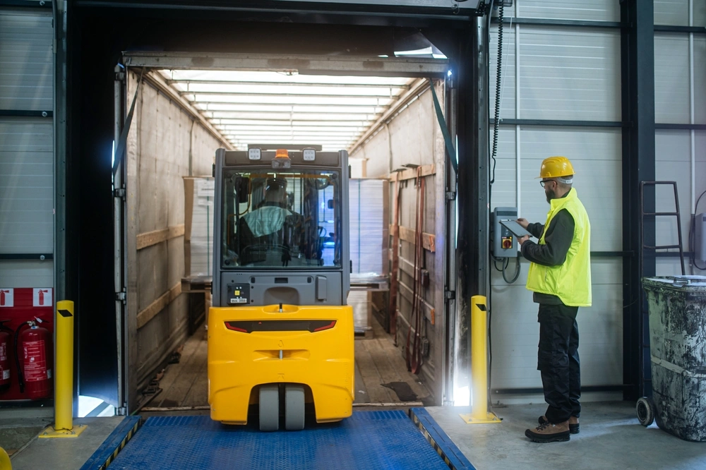 pallet truck loading items into a truck at warehouse dock