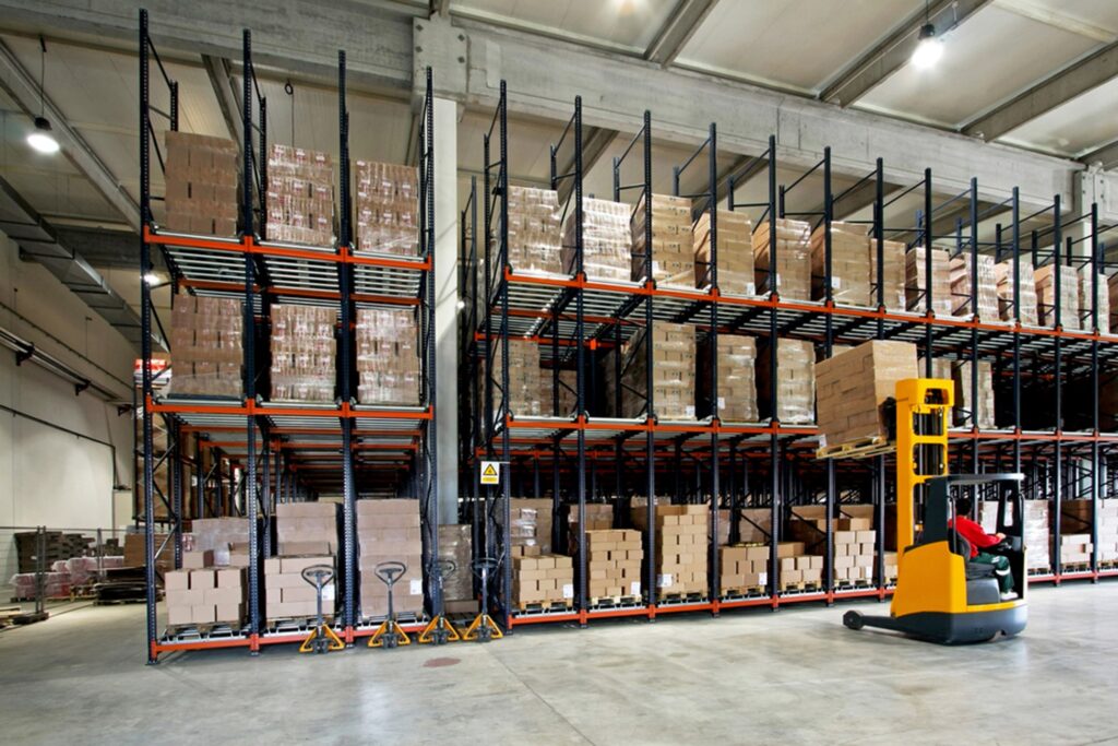 forklift putting a pallet on a rack in a warehouse