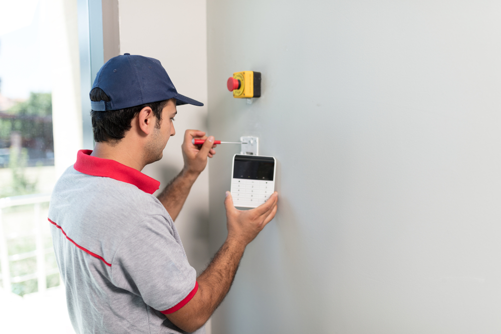 man installing warehouse security system panel