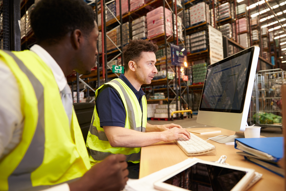 warehouse employees using cloud wms software on computer