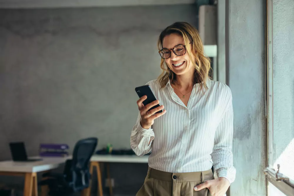 a business woman looking at her phone in an office